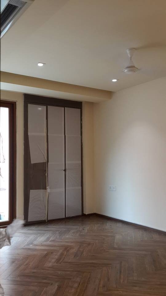 Master bedroom with herringbone wood flooring and recessed false ceiling lighting — GK I Residence