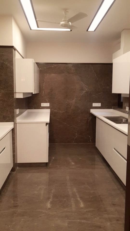 Full kitchen view showing three-run layout with continuous overhead storage and dark marble backsplash — Green Park Residence